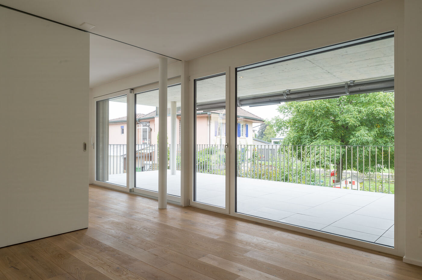 Wohnraum mit raumhohen Fenstern und Blick auf die Terrasse